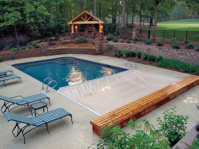 Custom automatic pool cover protecting an inground swimming pool